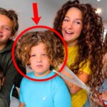 Group of smiling siblings posing together; a red circle marks a boy with curly hair as a pair of scissors hovers nearby, suggesting a haircut moment in progress.