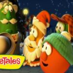Group of VeggieTales characters stand together in a snowy town at night, with the VeggieTales logo in the corner.