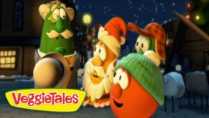 Group of VeggieTales characters stand together in a snowy town at night, with the VeggieTales logo in the corner.