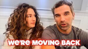 A man and a woman sit side by side, the woman gazing at him, with bold red text reading “WE'RE MOVING BACK” across the bottom.