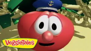 Close-up of a red round VeggieTales character with large eyes, a blue captain's hat with an anchor, and a smile.