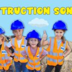 Five children in orange safety vests and blue hard hats pose on a sandy construction site with a bright blue sky and the words 'CONSTRUCTION SONG' above them.