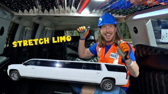 Man in a blue hard hat and orange safety vest holds a large toy stretch limo inside a vehicle, with 'STRETCH LIMO' text.