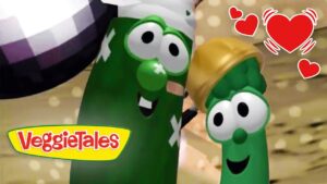 Two green VeggieTales vegetables share a hug with big googly eyes, pink cheeks, and a warm heart motif in the corner.