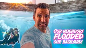 Man takes a selfie by a flooded backyard pool; scuba diver visible underwater on the left; large pink caption reads 'Our neighbors flooded our backyard!'