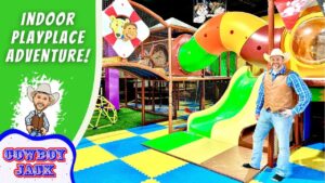 Cowboy-themed indoor play area with a man in cowboy gear beside a bright slide and colorful safety mats; text reads 'Indoor Playplace Adventure'.