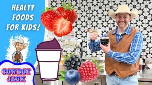 Promotional thumbnail with a cowboy-themed host holding a cup, oversized strawberries and berries, and bold text 'Healthy Foods for Kids' on a blue background.