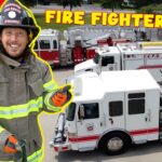 Young firefighter in turnout gear giving a thumbs-up, with fire trucks and a flame-themed background. Captioned 'FIRE FIGHTER SONG' at the top edge.