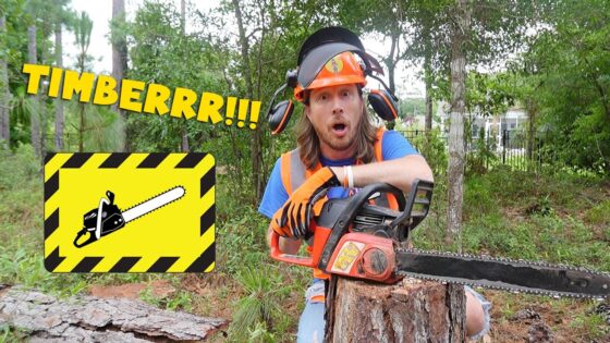 Man in safety gear with a running chainsaw cutting a log in a forest setting, surprised expression on his face.