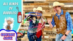 Cowboy couple in hats blowing bubbles at a wand, with a turquoise panel reading 'All Kinds of Bubbles!' and a 'Cowboy Jack' logo on the left.