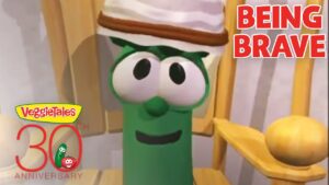 Green VeggieTales character with a hat, smiling, beside the 'Being Brave' title and 30th Anniversary logo on the lower left.