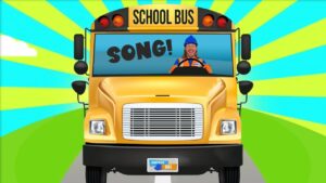 Front view of a yellow school bus with a smiling driver; the windshield reads 'SONG!' in bold letters against a bright, colorful background.