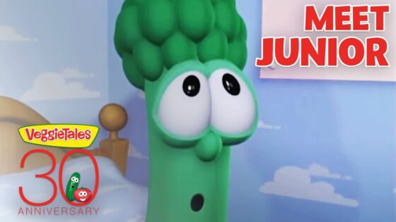Green veggie character with large eyes in a pastel room, saying 'Meet Junior' for VeggieTales 30th Anniversary.