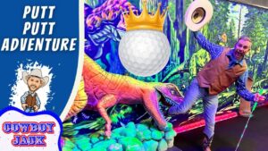 Man in a cowboy vest and hat poses with a neon dinosaur in a colorful putt-putt adventure scene; a crowned golf ball hovers above.