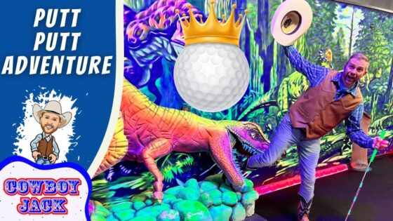 Man in a cowboy vest and hat poses with a neon dinosaur in a colorful putt-putt adventure scene; a crowned golf ball hovers above.