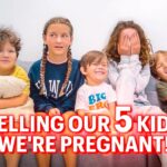 Five kids sit on a gray sofa, with a bold red text banner across the bottom that says 'Telling our 5 kids we're pregnant!'