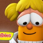Close-up of a cheerful orange VeggieTales character with yellow pigtails and a gentle smile, VeggieTales logo in the bottom-left corner.