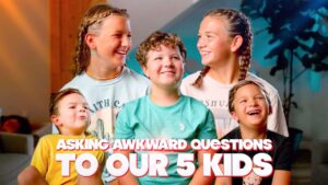 Five smiling kids posing indoors for a video thumbnail; bold title text across bottom reads 'Asking awkward questions to our 5 kids'.