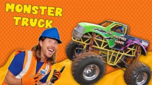 Smiling man in a blue hard hat and orange safety vest beside a bright green monster truck on an orange dotted background with 'MONSTER TRUCK' text above.