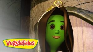 Green-skinned VeggieTales character wearing a brown hood and small crown, smiling in a stone arch setting with VeggieTales logo in the corner.