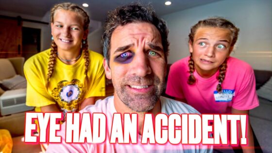 Center-close photo of a man with a bruised eye and purple makeup around it, flanked by two smiling girls in yellow and pink shirts, in a living room; bold caption 'EYE HAD AN ACCIDENT!' across the bottom.