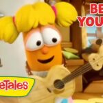 Orange VeggieTales character with yellow pigtails plays a guitar in a cozy kitchen scene; VeggieTales logo visible and 'Being Yourself' text top right.