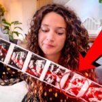 Woman with curly hair holding a long strip of ultrasound images, a red circle highlights a specific frame, and a large red arrow points to that area.