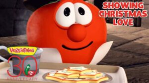 Red VeggieTales character with a mug and a plate of star-shaped cookies, celebrating VeggieTales 30th anniversary. Caption: Showing Christmas Love.