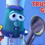 Green VeggieTales character with a magnifying glass against a blue background; title 'TRUSTING GOD' and a 30th anniversary logo nearby.