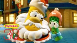 Two VeggieTales characters in a snowy town: a large yellow bearded figure beside a green cucumber in a pink hat, with a 30th anniversary logo nearby.