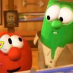 Green cucumber character in a beige coat chats with a red tomato character in a wood-paneled room; features VeggieTales 30th Anniversary logo in the corner.
