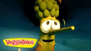 Animated VeggieTales character with a long corn-nose and wide eyes, against a blue backdrop. Seen with the VeggieTales logo in the corner.