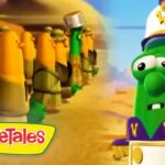 Green VeggieTales character in a captain’s hat faces a line of yellow-armored soldiers in a desert setting; VeggieTales logo bottom left.
