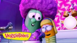 Two VeggieTales characters perform on a colorful stage, singing into microphones with a drum set in the background and the VeggieTales logo visible in the corner.