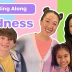 Colorful thumbnail with a smiling family and a banner reading 'Sing Along Kindness' for a kids' video about kindness.