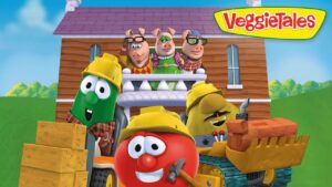 VeggieTales characters in hard hats at a construction site in front of a wooden house, tomato in front smiling with a hammer nearby.