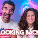 Smiling man and woman in a colorful tech-themed room with neon lights; bold 'LOOKING BACK' text overlays the bottom edge.