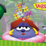 Three VeggieTales characters posing in a whimsical garden with a colorful flower bouquet and the VeggieTales sign in the background.