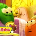 Green cucumber character smiles at an orange carrot in a bright, colorful VeggieTales set with the logo in the corner
