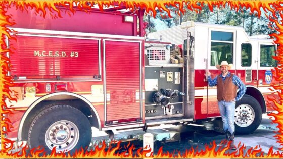 Red fire engine with chrome compartments, labeled M.C.E.S.D. #3, outdoors; a man in a cowboy hat stands beside it.