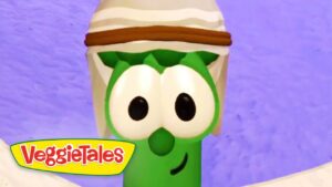 Larry the Cucumber from VeggieTales, wearing a white hat with a brown band, against a purple background.