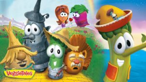 Group of VeggieTales characters posing on a sunny grassy hill, smiling at the camera.