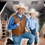 Man and boy in cowboy outfits posing in a photography studio with lights and props nearby.