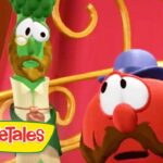 Two VeggieTales characters on a colorful stage, a green veggie with glasses and bow tie beside a red, mustached veggie in a blue hat, looking surprised.