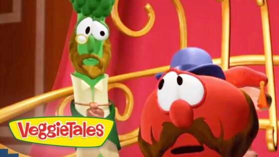 Two VeggieTales characters on a colorful stage, a green veggie with glasses and bow tie beside a red, mustached veggie in a blue hat, looking surprised.
