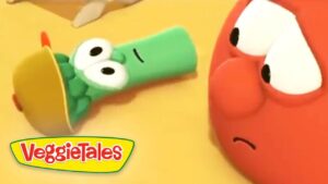 Green veggie wearing a brown hat lies on its side while a red, anxious-looking veggie watches; VeggieTales logo in the corner.