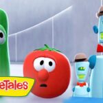 Green cucumber character and red tomato with surprised expressions, alongside two small blue robots wearing hats in a VeggieTales scene