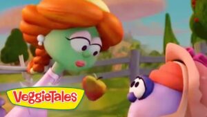 Green-skinned girl with orange hair hands an apple to a purple creature in a sunny farm scene; VeggieTales logo at the bottom left.