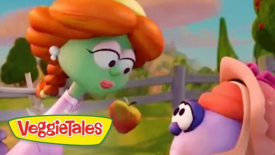 Green-skinned girl with orange hair hands an apple to a purple creature in a sunny farm scene; VeggieTales logo at the bottom left.