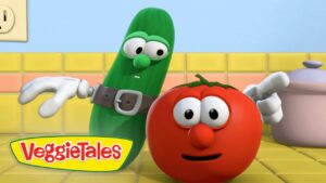 Animated VeggieTales scene: a green cucumber in a belt beside a smiling red tomato in a bright yellow-tiled kitchen near a pot.